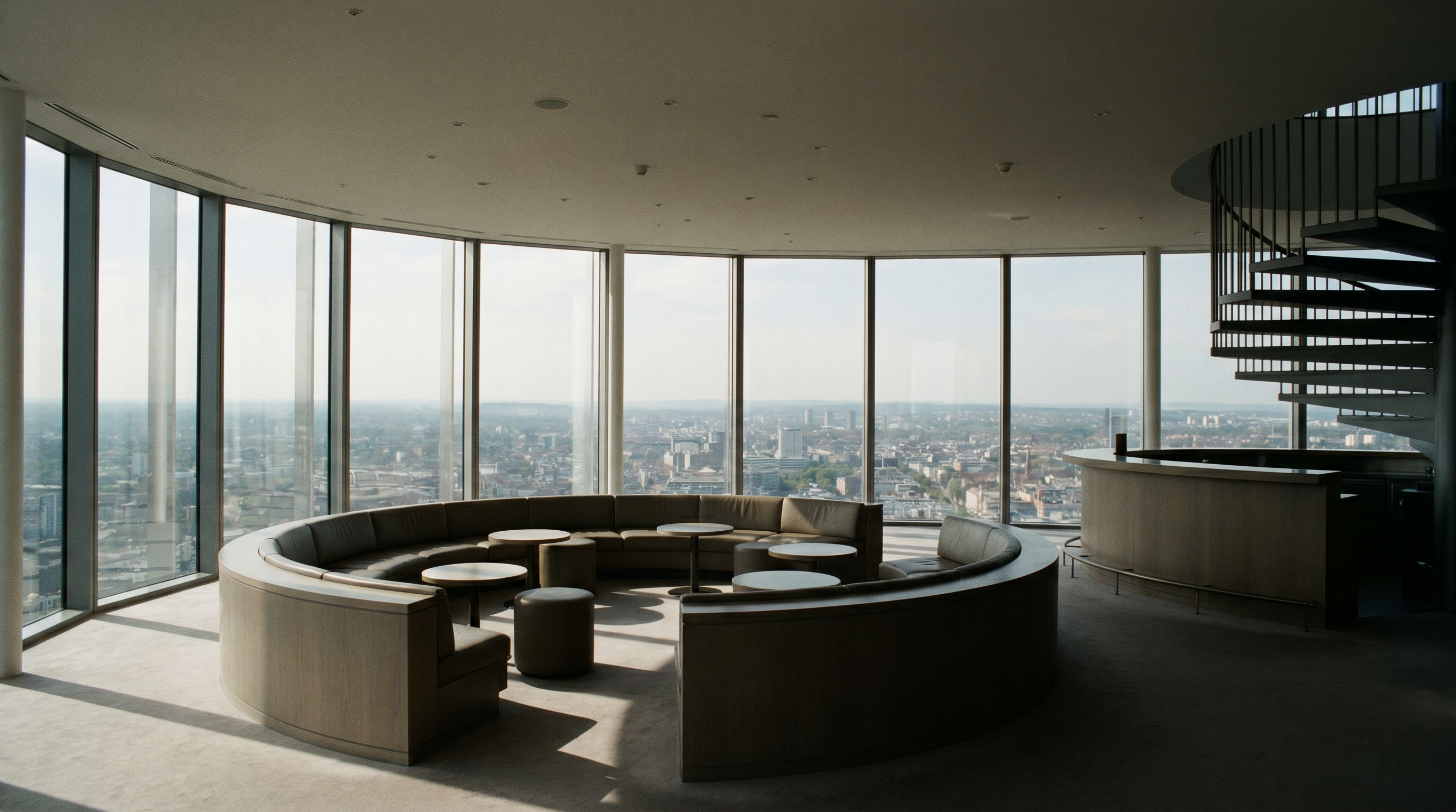 A sunlit modern penthouse lounge overlooking the city at golden hour